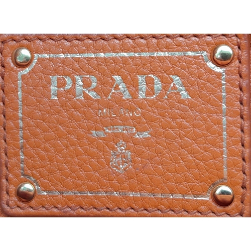 113 - A Prada Orange Vitello Daino Satchel Bag. Leather exterior, gold-tone hardware, double rolled leathe... 