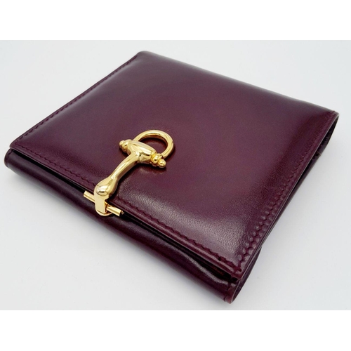 239 - A Launer Burgundy Wallet. Leather exterior, gold-tone metal clasp that open to reveal six card slots... 