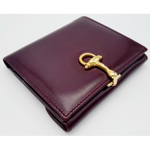 239 - A Launer Burgundy Wallet. Leather exterior, gold-tone metal clasp that open to reveal six card slots... 