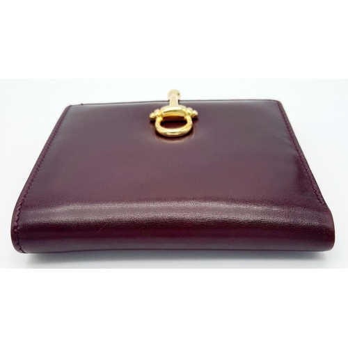 239 - A Launer Burgundy Wallet. Leather exterior, gold-tone metal clasp that open to reveal six card slots... 