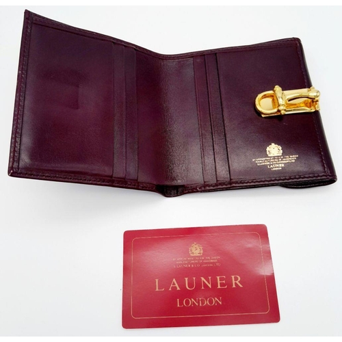 239 - A Launer Burgundy Wallet. Leather exterior, gold-tone metal clasp that open to reveal six card slots... 