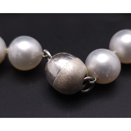 134 - A Sumptuous Natural South Sea White Pearl Necklace. Rich white 8-14mm pearls with silver clasp. 42cm... 