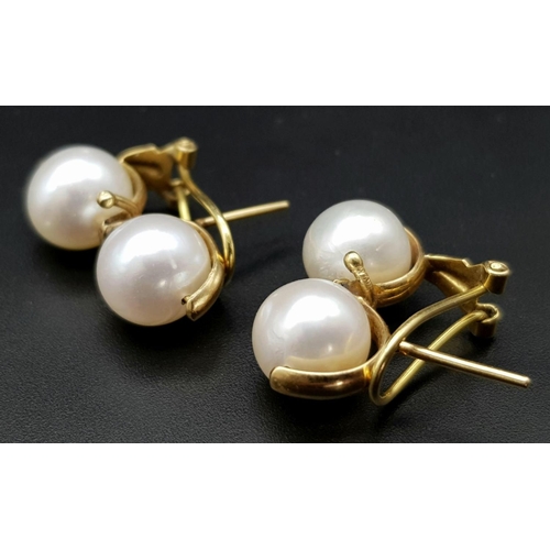 246 - A Pair of 18K Yellow Gold Twin South Sea Pearl Earrings. Clip design. 10mm pearls. 9g total weight.