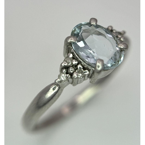 330 - A Vintage 900 Platinum Blue Topaz and Diamond Ring. Oval cut 1ct topaz with diamond accents. Size O.... 