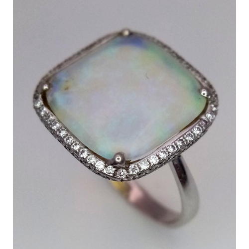 337 - An 18K White Gold Opal and Diamond Ring. Square cut translucent opal with excellent colour-play and ... 