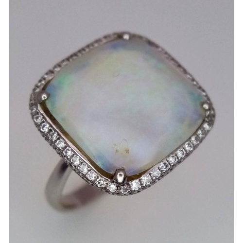 337 - An 18K White Gold Opal and Diamond Ring. Square cut translucent opal with excellent colour-play and ... 