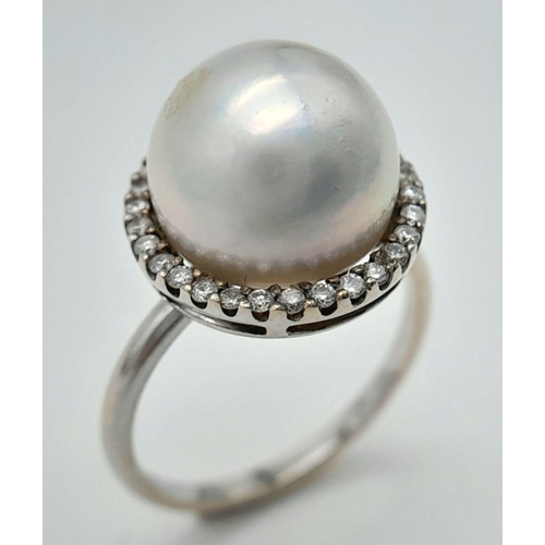 421 - An 18K White Gold South Sea Pearl and Diamond Ring. A South Sea Pearl Cabochon with diamond halo. Si... 