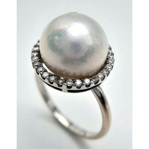 421 - An 18K White Gold South Sea Pearl and Diamond Ring. A South Sea Pearl Cabochon with diamond halo. Si... 