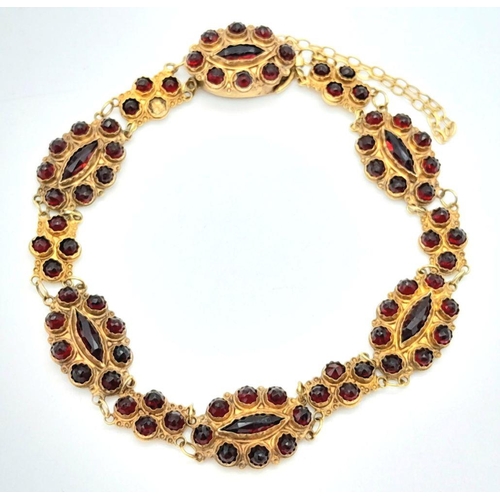 533 - A Vintage 18K Yellow Gold Garnet Bracelet. Rich links of round and marquise cut garnets. 16cm. safet... 