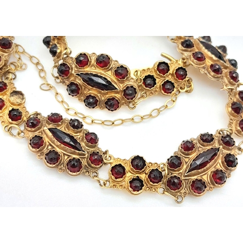 533 - A Vintage 18K Yellow Gold Garnet Bracelet. Rich links of round and marquise cut garnets. 16cm. safet... 