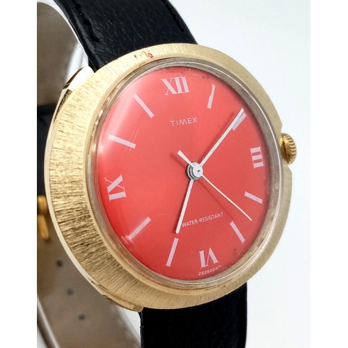 1399 - A Vintage, Red Oval Face, Gold Tone, Timex Manual Wind Watch. 40mm including crown. Full Working Ord... 