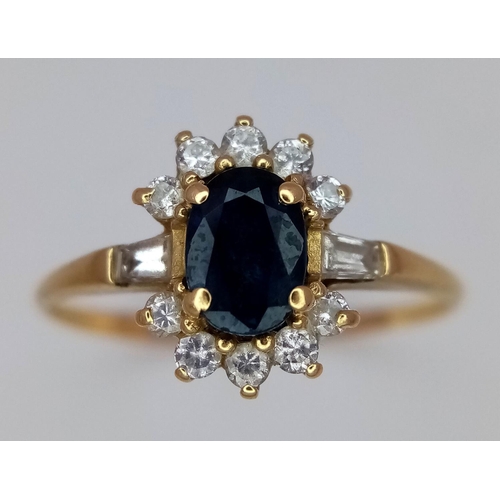 101 - An 18K Yellow Gold (tested) Diamond and Sapphire Ring. Central oval sapphire with a diamond surround... 