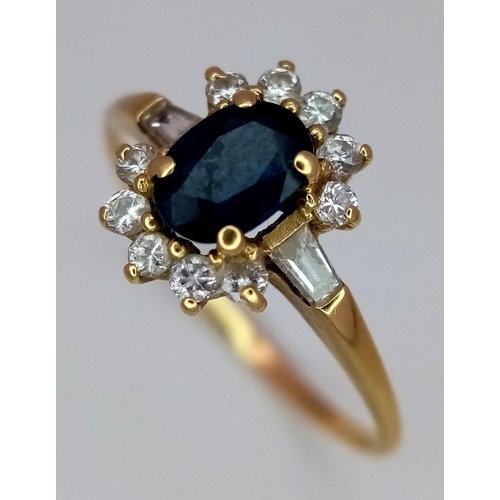 101 - An 18K Yellow Gold (tested) Diamond and Sapphire Ring. Central oval sapphire with a diamond surround... 