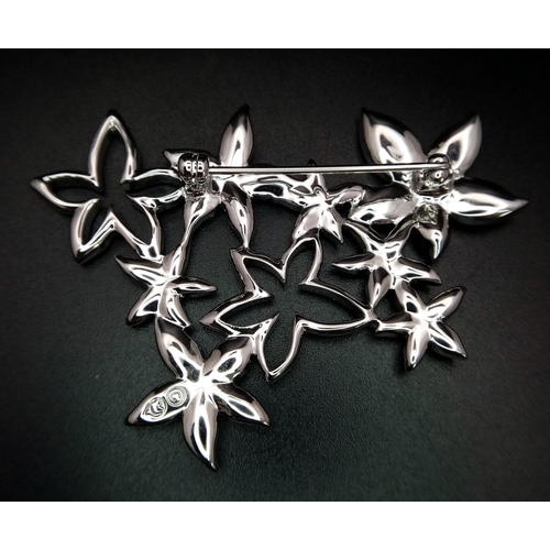 1403 - A new Swarovski silver tone star flower brooch, 6 x 4.5cm, Comes with original packaging and certifi... 