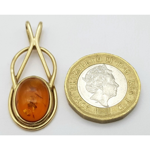 24 - A 9K Yellow Gold Amber Cabochon Pendant. 4cm. 3.5g total weight.