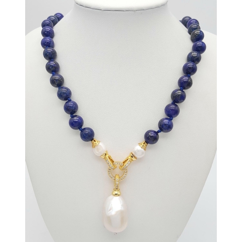 241 - A Lapis Lazuli Beaded Necklace with a Hanging Baroque Pearl Pendant. Gilded clasp with white stone a... 