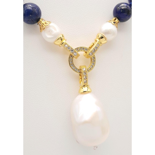 241 - A Lapis Lazuli Beaded Necklace with a Hanging Baroque Pearl Pendant. Gilded clasp with white stone a... 