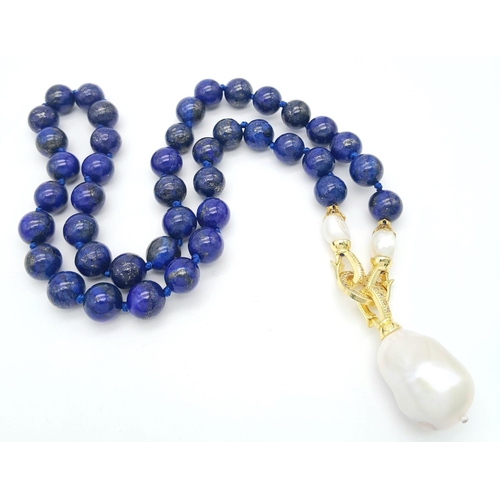 241 - A Lapis Lazuli Beaded Necklace with a Hanging Baroque Pearl Pendant. Gilded clasp with white stone a... 