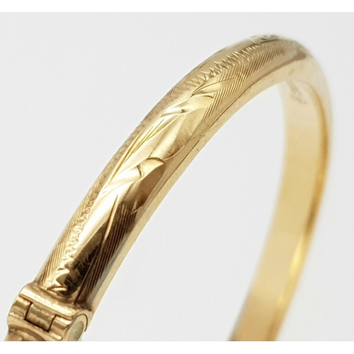 248 - A 9K Yellow Gold Bangle. Clip design with safety chain. 6cm inner diameter. 8.25g.