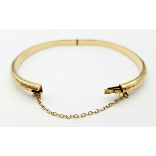 248 - A 9K Yellow Gold Bangle. Clip design with safety chain. 6cm inner diameter. 8.25g.