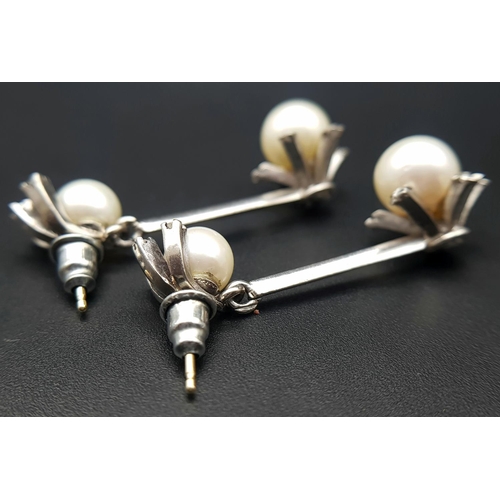 274 - A Pair of 18K White Gold, South Sea Pearl and Diamond Bar Drop Earrings. 16 petit brilliant round cu... 