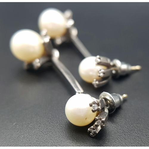 274 - A Pair of 18K White Gold, South Sea Pearl and Diamond Bar Drop Earrings. 16 petit brilliant round cu... 