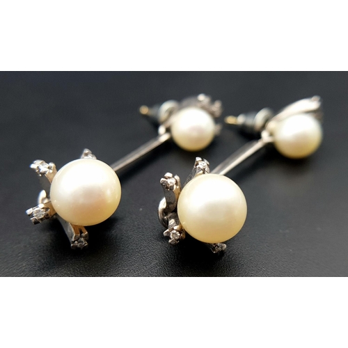 274 - A Pair of 18K White Gold, South Sea Pearl and Diamond Bar Drop Earrings. 16 petit brilliant round cu... 