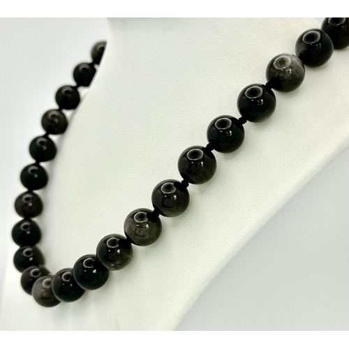 442 - A 'Silver Eye' Black Obsidian Beaded Necklace. 12mm beads.
48cm necklace length.