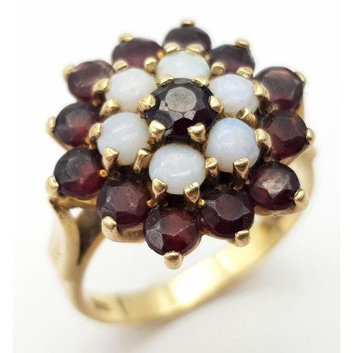22 - A Vintage 9K Yellow Gold Garnet and Opal Ring in Floral Form. Size Q. 5.1g total weight.