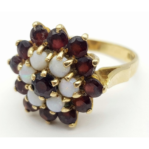 22 - A Vintage 9K Yellow Gold Garnet and Opal Ring in Floral Form. Size Q. 5.1g total weight.