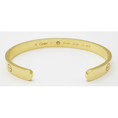 11 - A Cartier 18K Yellow Gold and Solitary Diamond Cuff Bangle. Classic Cartier design with full Maker/H... 