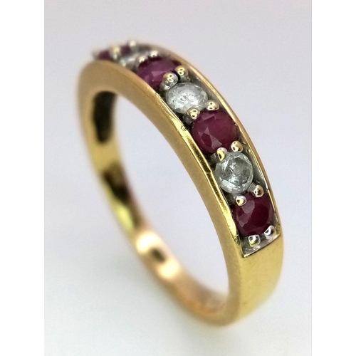 221 - An 18K Yellow Gold Ruby and Diamond Seven Stone Ring. 
Size N. 3.19g. Ref: 17877