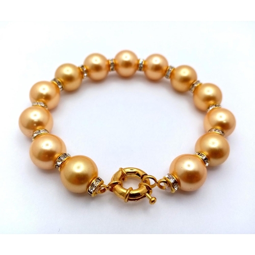 1664 - A Golden South Sea Pearl Shell Beaded Bracelet with Gilded Clasp and white stone accent spacers. 12m... 