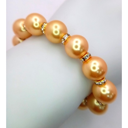 1664 - A Golden South Sea Pearl Shell Beaded Bracelet with Gilded Clasp and white stone accent spacers. 12m... 