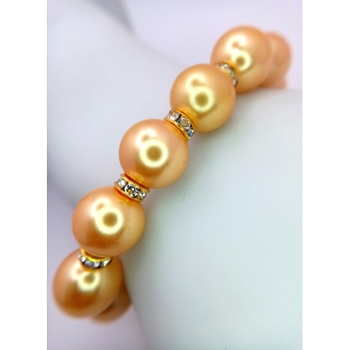 1664 - A Golden South Sea Pearl Shell Beaded Bracelet with Gilded Clasp and white stone accent spacers. 12m... 