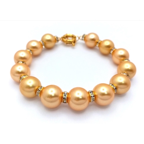 1664 - A Golden South Sea Pearl Shell Beaded Bracelet with Gilded Clasp and white stone accent spacers. 12m... 