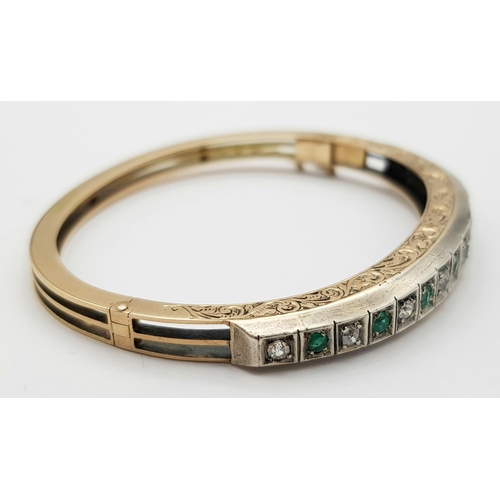 102 - A 9K Gold Emerald and Diamond Set Bangle. Clip design with safety chain. Alternating diamonds and em... 