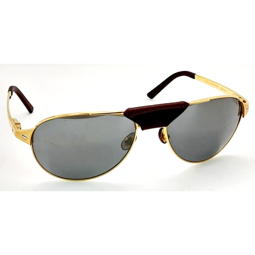 193 - A Pair of Designer Cartier Santos Sunglasses. Gilded frames with the classic screw design. Comes wit... 