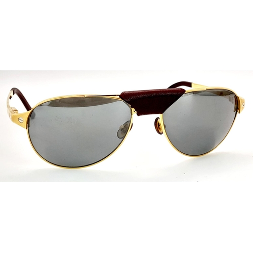 193 - A Pair of Designer Cartier Santos Sunglasses. Gilded frames with the classic screw design. Comes wit... 