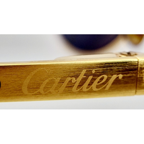 193 - A Pair of Designer Cartier Santos Sunglasses. Gilded frames with the classic screw design. Comes wit... 