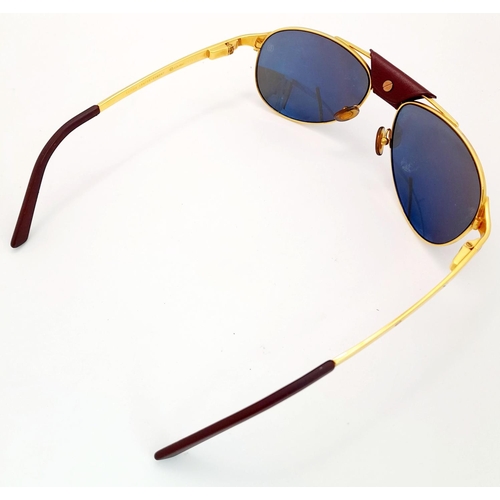 193 - A Pair of Designer Cartier Santos Sunglasses. Gilded frames with the classic screw design. Comes wit... 