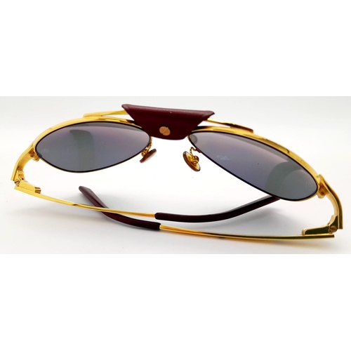 193 - A Pair of Designer Cartier Santos Sunglasses. Gilded frames with the classic screw design. Comes wit... 