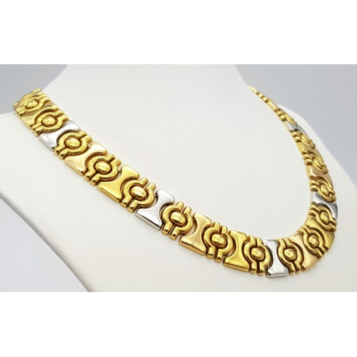 25 - A Gorgeous 18K Yellow and White Gold Necklace. Geometric, articulated design. 14mm width. 42cm neckl... 