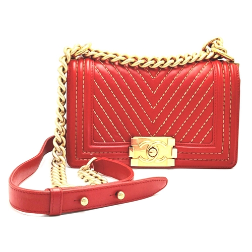 34 - A Chanel Red Boy Bag. Quilted leather exterior with gold-tone hardware, leather and chain strap and ... 