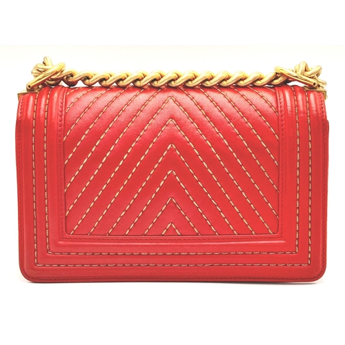 34 - A Chanel Red Boy Bag. Quilted leather exterior with gold-tone hardware, leather and chain strap and ... 