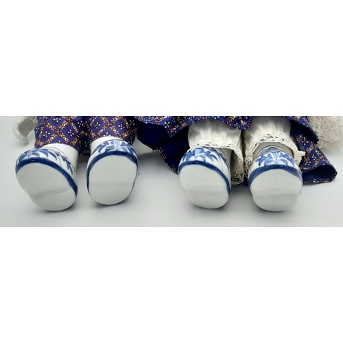 276 - A pair of Chinese Blue & White porcelain dolls – a boy and a girl – in traditional clothing, export ... 