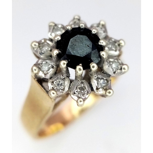 431 - A 9K GOLD RING WITH A SAPPHIRE SURROUNDED BY DIAMONDS .     4.1gms   size N