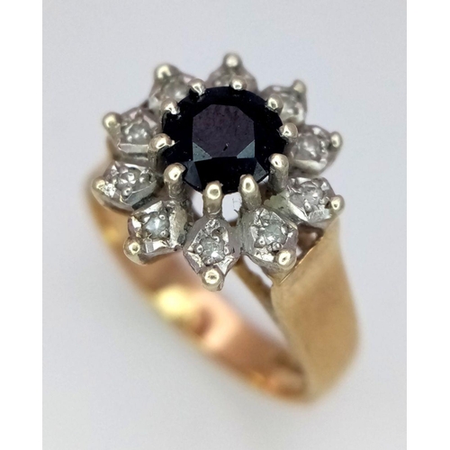 431 - A 9K GOLD RING WITH A SAPPHIRE SURROUNDED BY DIAMONDS .     4.1gms   size N