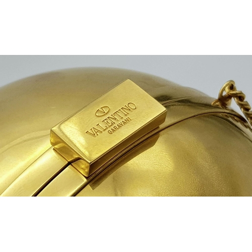 67 - A Valentino Gold Orb Clutch Bag. Metal exterior with a stone embellished V logo and clasp fastening ... 