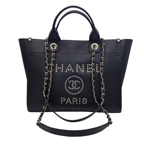 27 - A Chanel Deauville Tote Bag. Black leather exterior with gold tone hardware. Chanel, Paris silver to... 